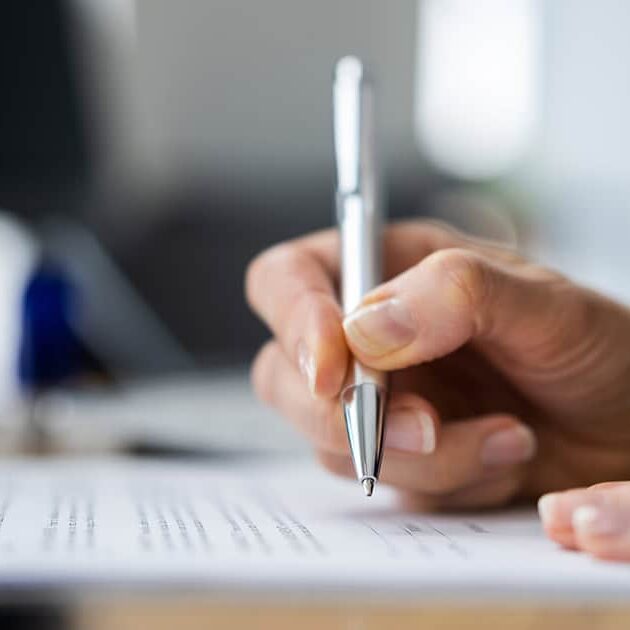 shutterstock_1890415048 - social A hand signing papers / shutterstock.com
