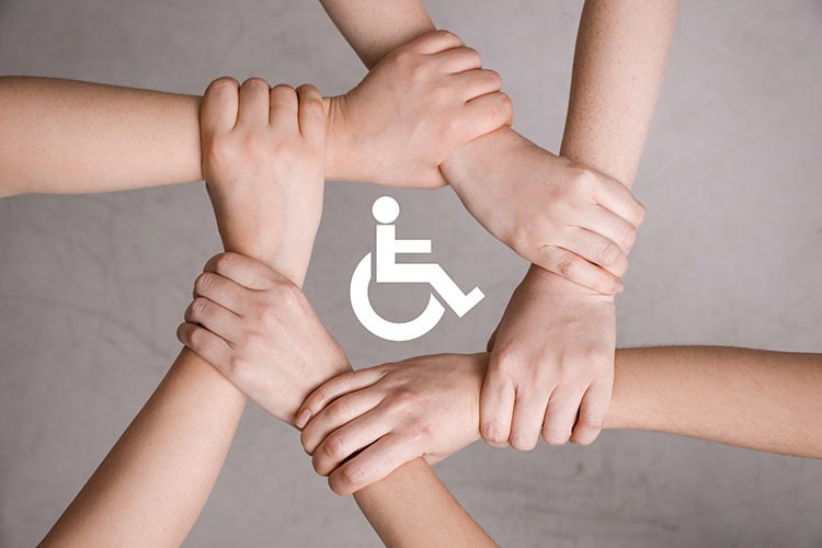 Inclusion,Concept.,People,Holding,Hands,Together,Around,International,Symbol,Of Inclusion concept. People holding hands together around international symbol of access together on grey background, top view/ shutterstock.com