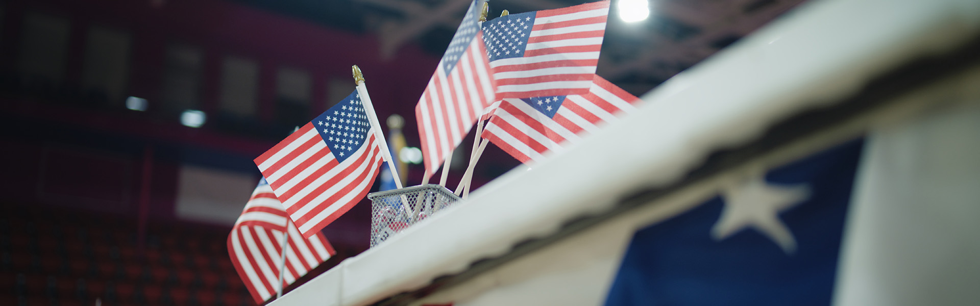 Close up of table for voting registration with American flags standing at polling place / shutterstock.com